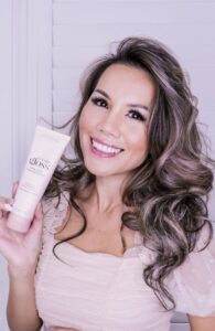 Rachel Vogt with curly hair holding a L'Oréal hair product